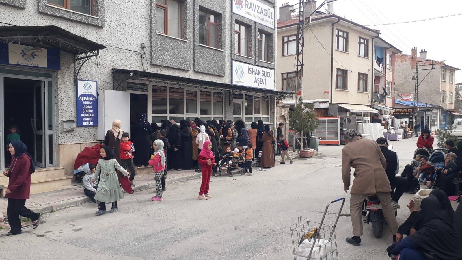 Hizmet binasının önünde dağıtım gününde bir araya gelen aileler