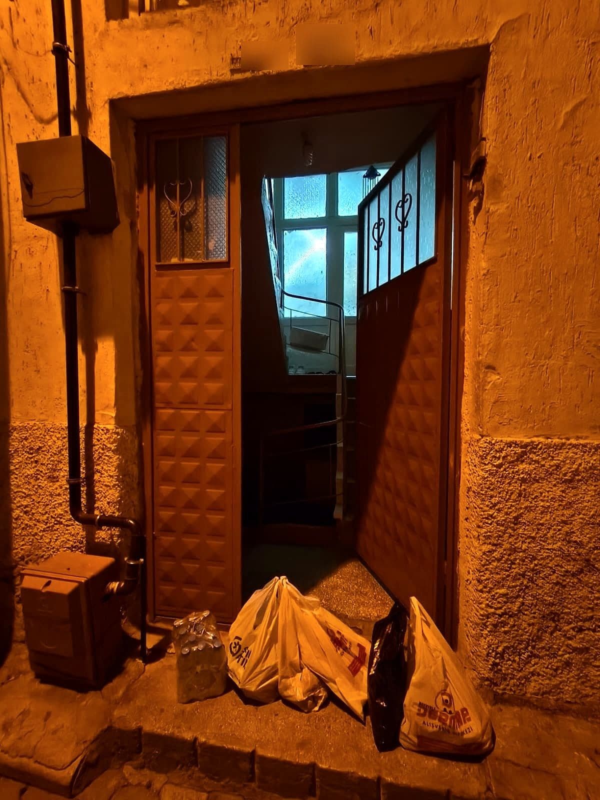 Ev kapısının önünde bekleyen gıda poşetleri ve su