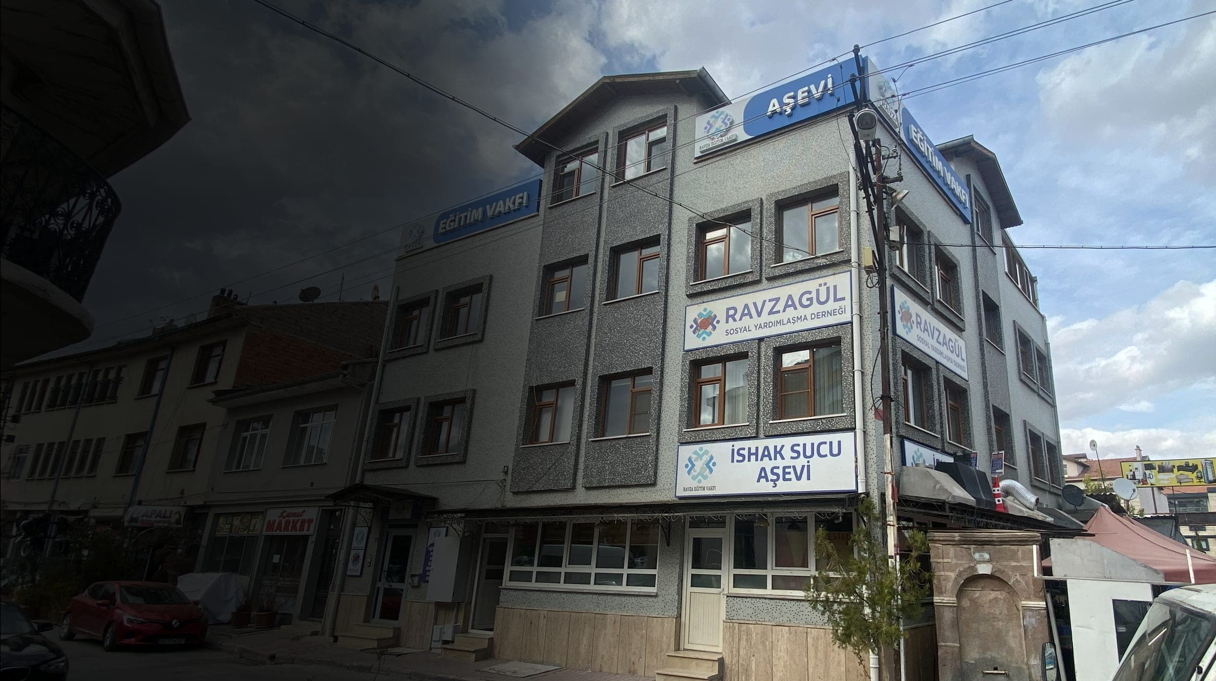 Bulutlu bir günde vakfın dört katlı hizmet binası ve Ravzagül Derneği tabelası