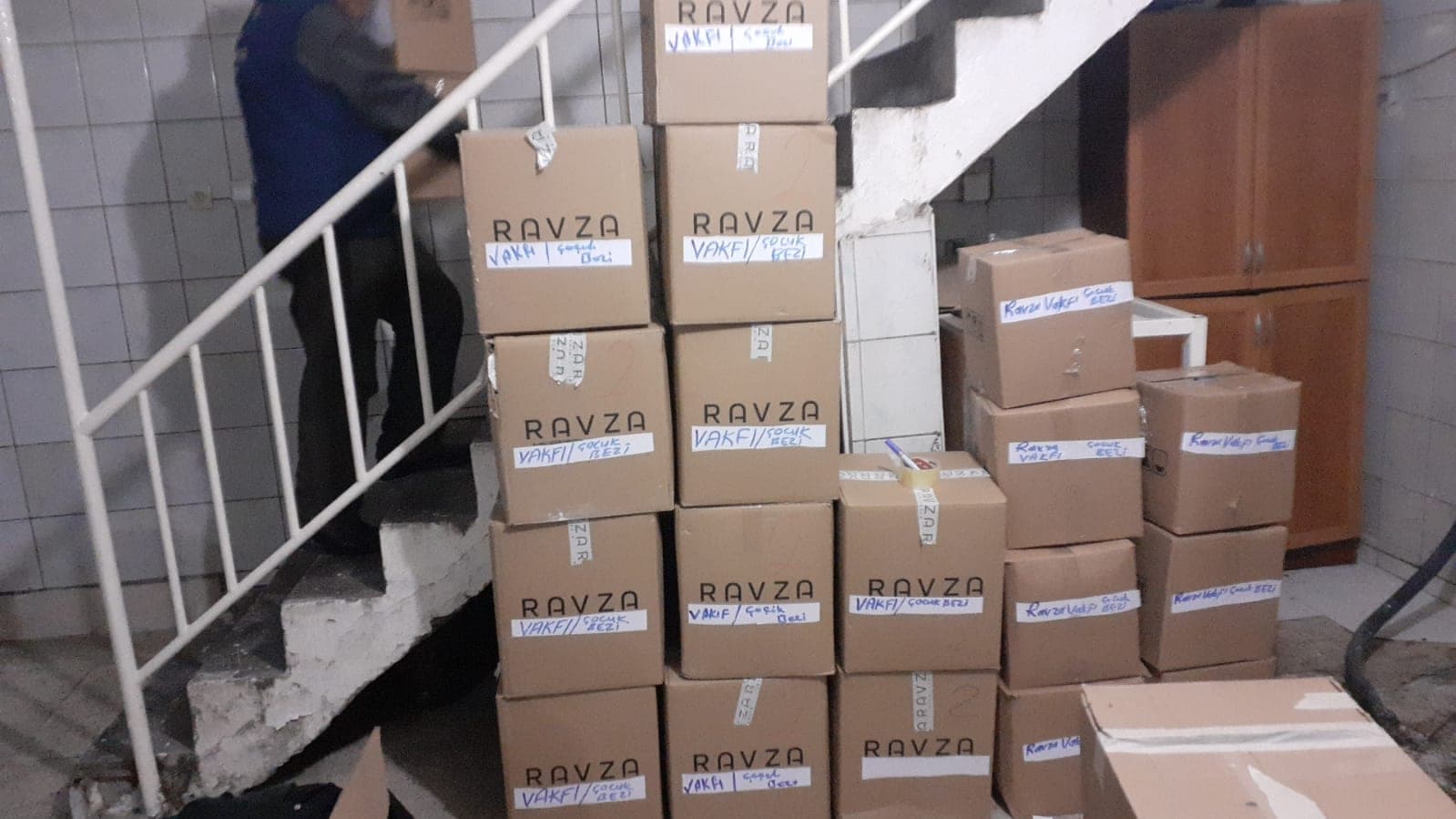 Ravza Vakfı etiketli yardım kolileri depoda üst üste dizilmiş